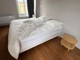 un lit blanc recouvert d'une couette blanche dans une chambre