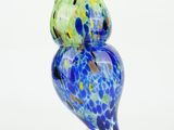 brightly colored glass owl figurine on clear base on white background