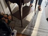 une femme utilisant un ordinateur portable posé sur une petite table dans un salon