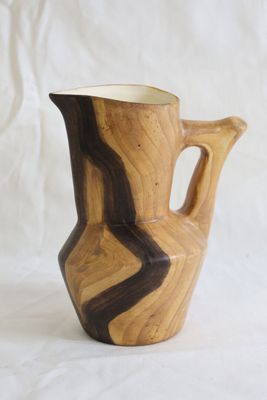 un vase en bois posé sur une surface blanche
