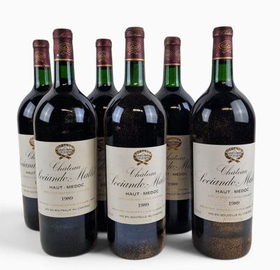 four bottles of red wine are lined up on a white surface