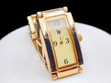 une montre en or posée sur une assiette blanche, sur une table