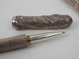 a pen that is laying on a table next to a piece of wood