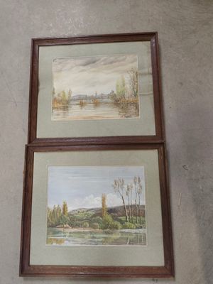 deux tableaux encadrés représentant une rivière et un paysage, accrochés au mur