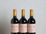 trois bouteilles de vin posées sur une table en bois