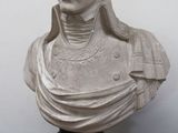 buste en marbre représentant un homme aux cheveux longs, vêtu d'une chemise à col