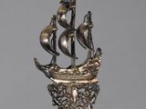 a silver statue of a ship on top of a table