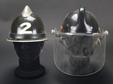 pair of firemen ' s helmets with face shields on display against a black background