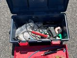 une boîte à outils contenant des outils, posée sur le sol