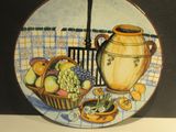 une assiette sur laquelle est représenté un pot et une corbeille de fruits