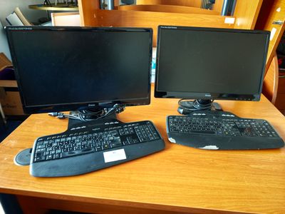 deux écrans d'ordinateur et un clavier sur un bureau