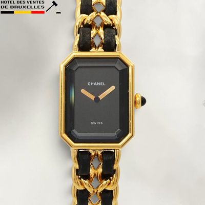 a black and gold watch with a chain around it