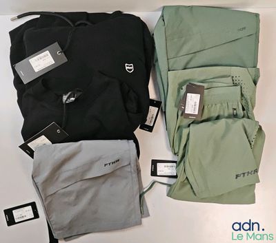 trois paires de pantalons et un sac à dos posés sur une table