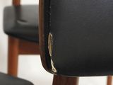close up of the back of a black leather chair with a wooden frame