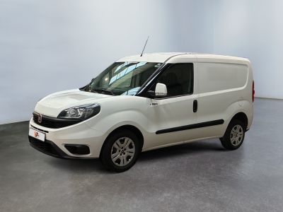 La petite camionnette blanche est garée dans une grande pièce.