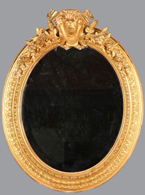 un miroir ancien dans un cadre doré, orné d'une tête de lion
