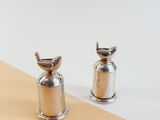 silver salt and pepper shakers sitting on top of a yellow and white table