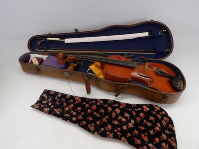 un violon et une cravate dans un étui posé sur une table