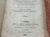 un vieux livre posé sur une table à côté d'une tasse de café