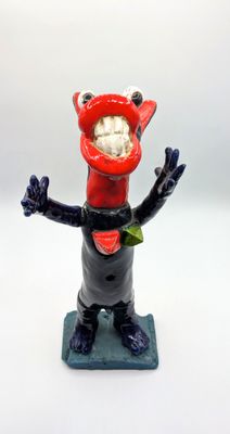 une figurine représentant un chat portant un bonnet rouge et une écharpe
