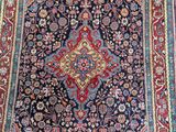 an antique persian rug with a floral design on a blue ground