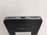 the back of a black cell phone sitting on top of a white table