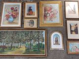 a lot of framed pictures on the floor of this room