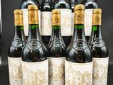 six bouteilles de vin sont alignées sur une table
