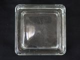 a glass square container on a black surface