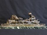 bronze statue of a boy on a log with a dog