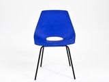 une chaise en plastique bleue avec des pieds noirs et un trou dans l'assise