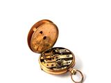 a gold pocket watch with a keychain on a white surface