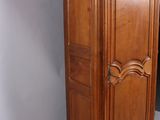 a tall wooden cabinet with a mirror on top of it