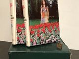 an old book with a picture of a woman standing in a field of flowers