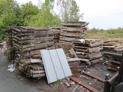 a large pile of wood sitting on the side of the road