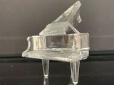 un piano en verre transparent posé sur une table noire