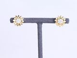 une paire de boucles d'oreilles en or et diamants, présentée sur un présentoir