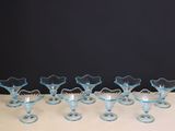 six vases en verre bleu posés sur une table blanche
