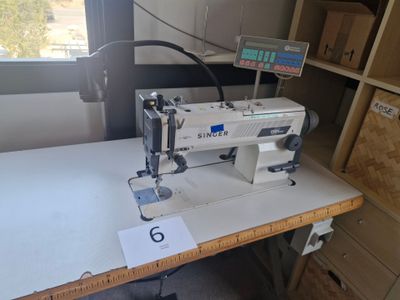 une machine à coudre posée sur une table dans une pièce