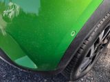 a close up of a green car with black rims