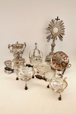 several silver and glass items are arranged on a white surface