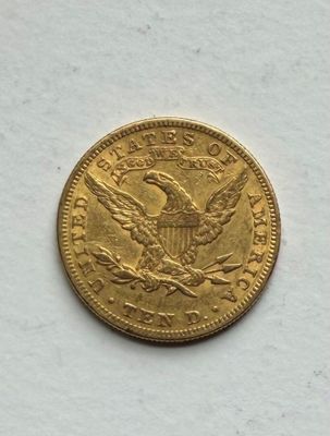 a close up of a gold coin on a white surface