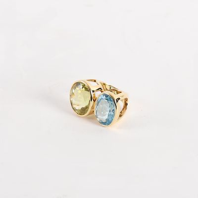a close up of a gold ring with two different colored stones