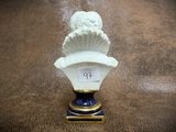 a white vase with a blue base and a gold base