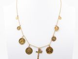 a gold necklace with coins and a cross on a mannequin