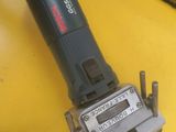 an electric tool sitting on top of a yellow table next to a keyboard
