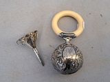 a silver object with a ring on it next to a pair of scissors
