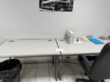une table blanche avec une chaise noire et un tableau accroché au mur