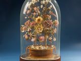 a glass dome with flowers inside of it on a blue surface