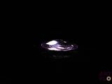 a close up of a purple diamond on a black surface